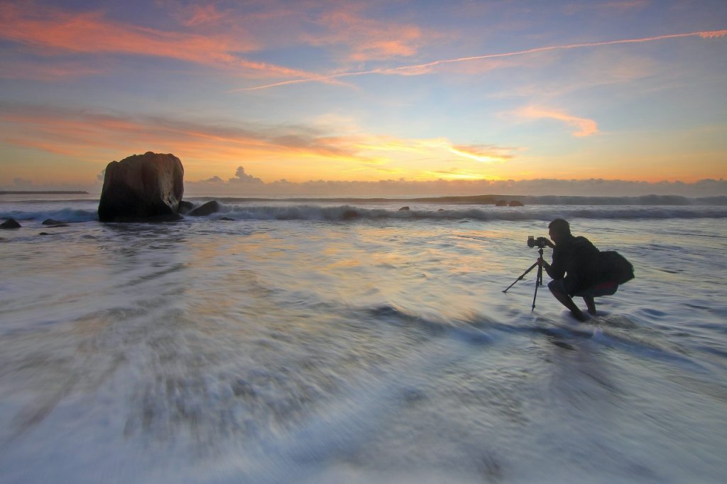 Photographer taking a photo of the sunset on the the water
